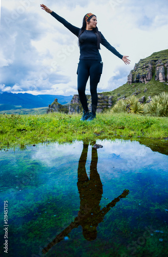 woman in black on the mountain with reflection in water