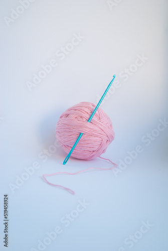 Pink threads with a ball lie on a white background.