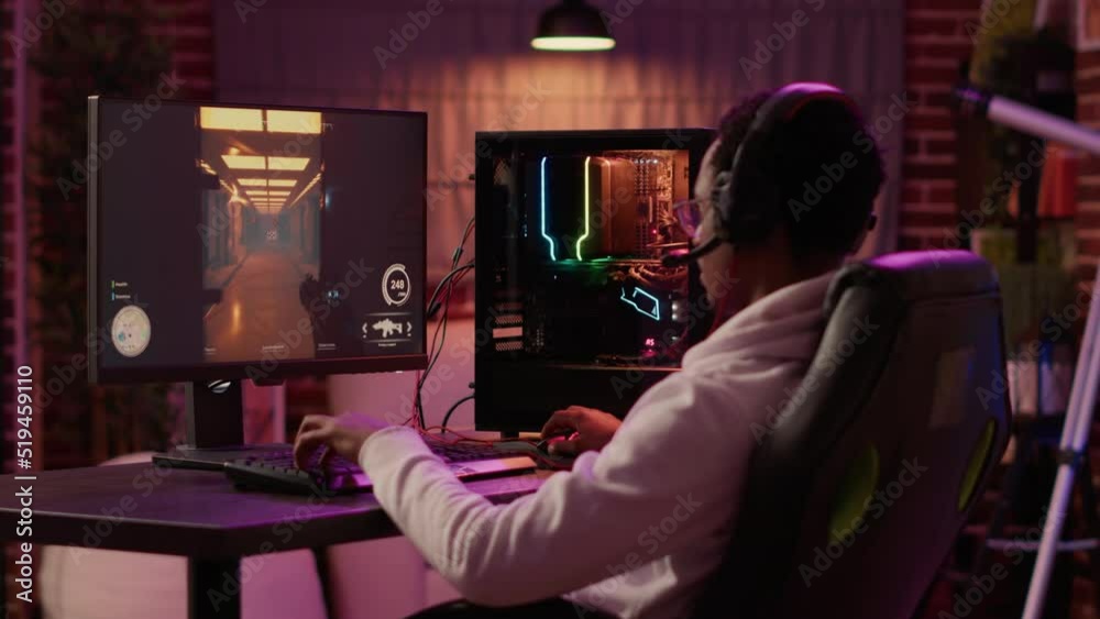 African american gamer having intense experience streaming online first person shooter game on pc station at home. Man playing intense action game in tournament talking with team using gaming headset. African american gamer having intense experience streaming online first person shooter game on pc station at home. Man playing intense action game in tournament talking with team using gaming headset.