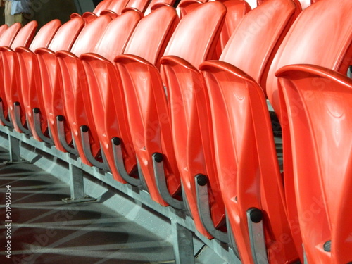 Empty row of red seats inside a sports stadium