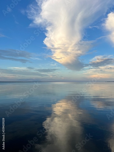 dramatic clouds reflecting onto still bay water