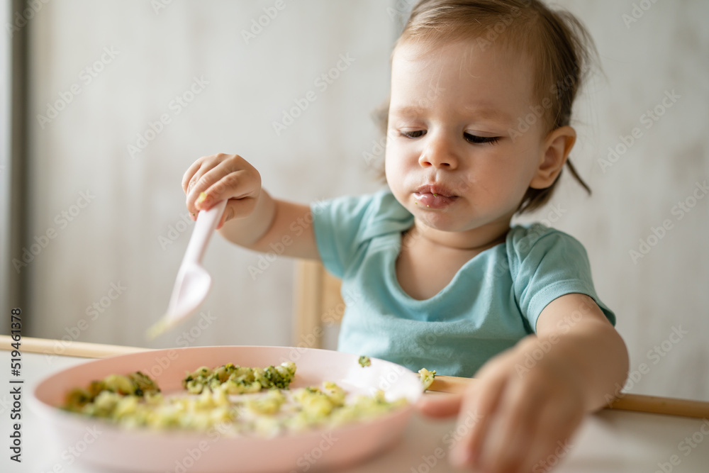 one girl small caucasian child one year old eat at the table at home one girl small caucasian child one year old eat at the table at home