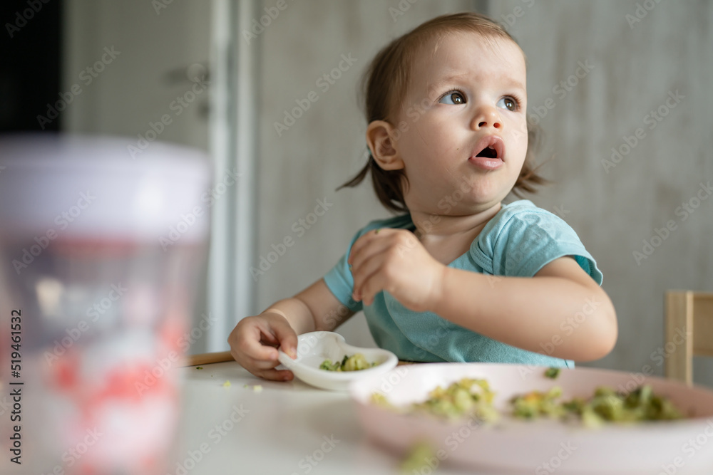 one girl small caucasian child one year old eat at the table at home one girl small caucasian child one year old eat at the table at home