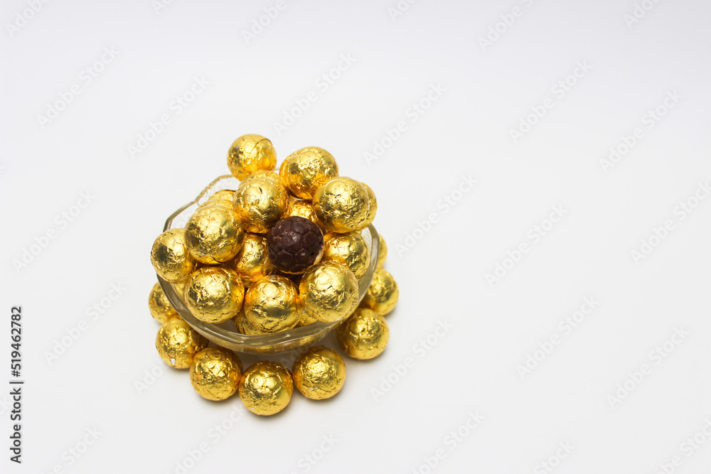 Soccer Ball-shaped chocolates in gold foil rotating on a white background Soccer Ball-shaped chocolates in gold foil rotating on a white background