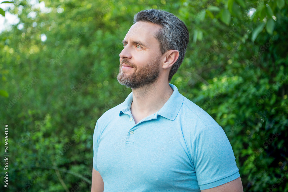 Portrait of handsome guy in blue tshirt looking aside natural background Portrait of handsome guy in blue tshirt looking aside natural background