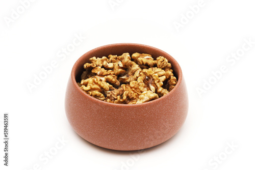 Walnut in a clay bowl on a white background. Close-up