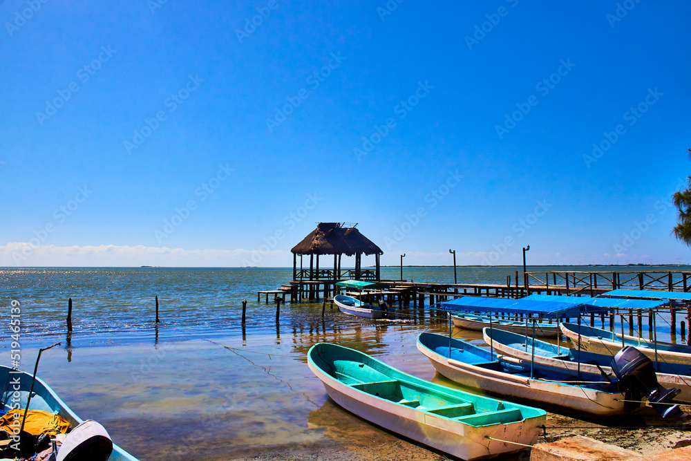 boats at a dock and jetty with blue sky in the lagoon of isla aguada campeche 