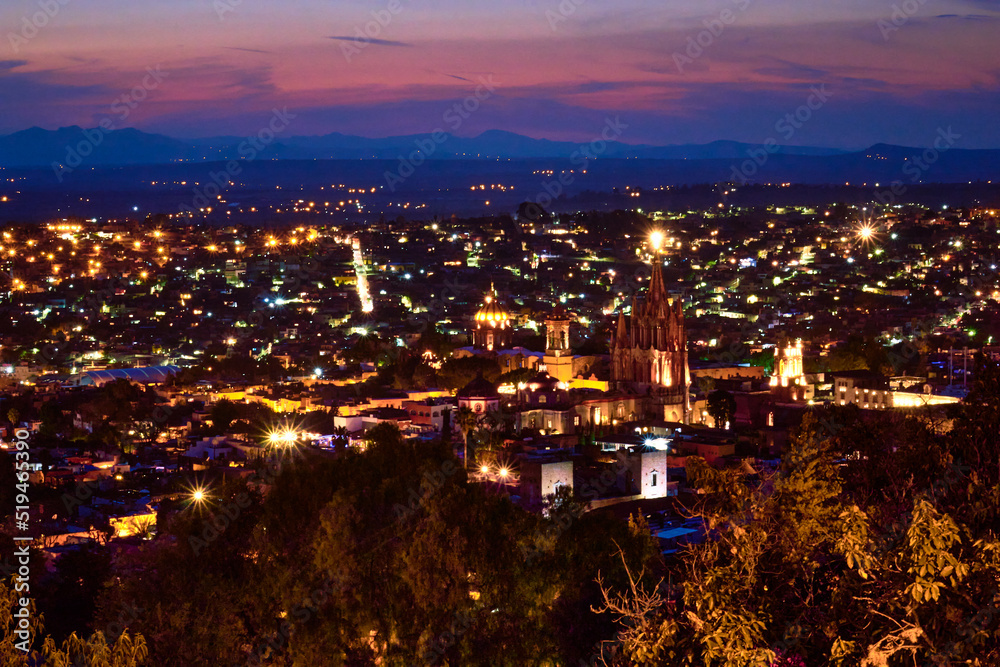 city at night with brigh lights and purpple sky and big parish in san miguel de allende guanajuato 