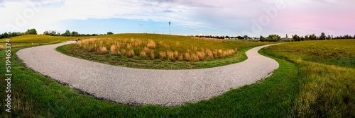 Tranquil hilly meadow gentle sunset landscape with curved footpaths at A.E. Wilson Park in Regina, Saskatchewan, Canada