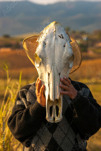 Portrait of a cowboy wearing a cow skull as a mask