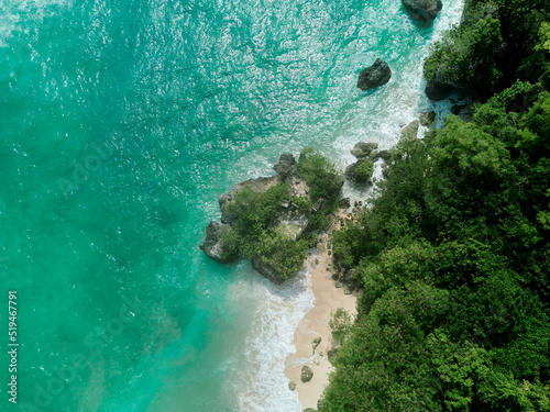Fototapeta Naklejka Na Ścianę i Meble -  aerial drone view of padang padang beach in bali with waves, rocks and forest