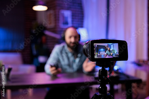 Vlogging creator using camera to record podcast episode in filming studio with modern equipment. Online influencer recording live video discussion to have fun on internet channel. Livestream. photo