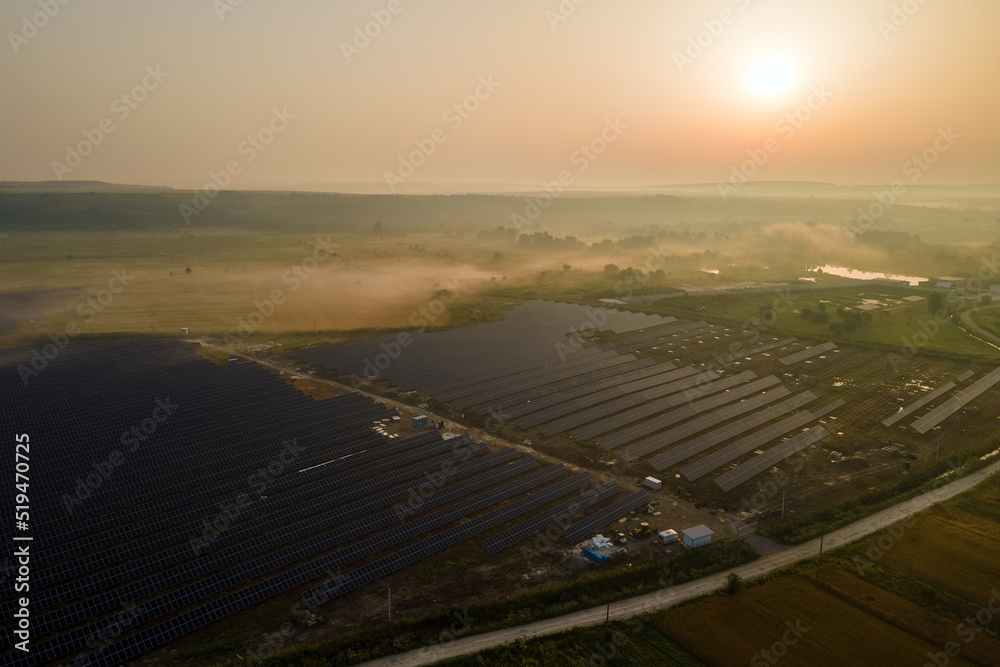 Aerial view of large sustainable electrical power plant with rows of solar photovoltaic panels for producing clean electric energy in evening. Concept of renewable electricity with zero emission