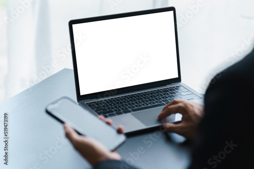 Young man working on his laptop with blank copy space screen in office, Back view of business man hands busy using laptop at office desk.
