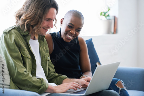 Friends using laptop computer at home browsing internet watching online entertainment