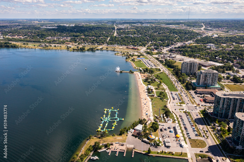 Obraz premium Centennial beach drone shot blue water clouds green grass sand beach and on water park