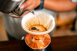 Drip coffee barista pouring water on coffee ground with filter
