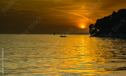 Wallpaper Mural View from the bay in the city of Cavtat-Croatia, late sunset with a small boat in the background, June, colors: gray, black and gold Torontodigital.ca