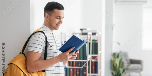 Male student reading book i...