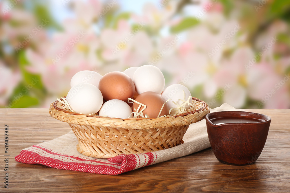 Wicker bowl with chicken eggs on wooden table outdoors Wicker bowl with chicken eggs on wooden table outdoors