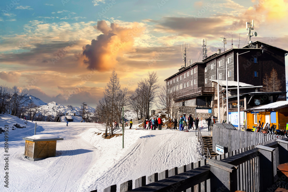 Fototapeta premium People skiing in Vogel, Slovenia. Sunny weather in the mountains on a perfect ski slope. Slopes in a beautiful ski resort on a sunny winter day.