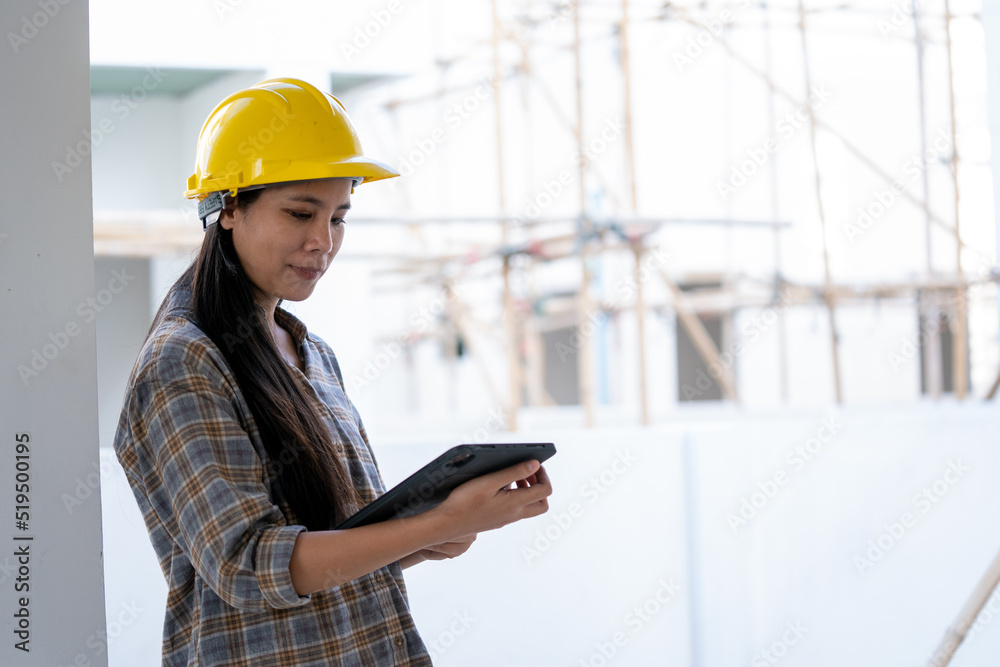 Construction workers in helmets at building site working using tablet. Construction workers in helmets at building site working using tablet.