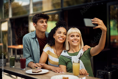 Group of young people having fun while taking selfie in cafe.