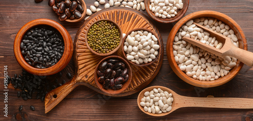 Different legumes on wooden background, top view