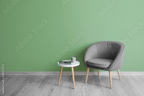 Fototapeta Naklejka Na Ścianę i Meble -  Comfortable armchair with table near green wall in room