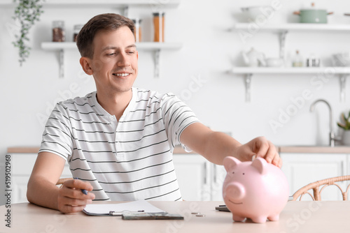 Young man putting coin into...