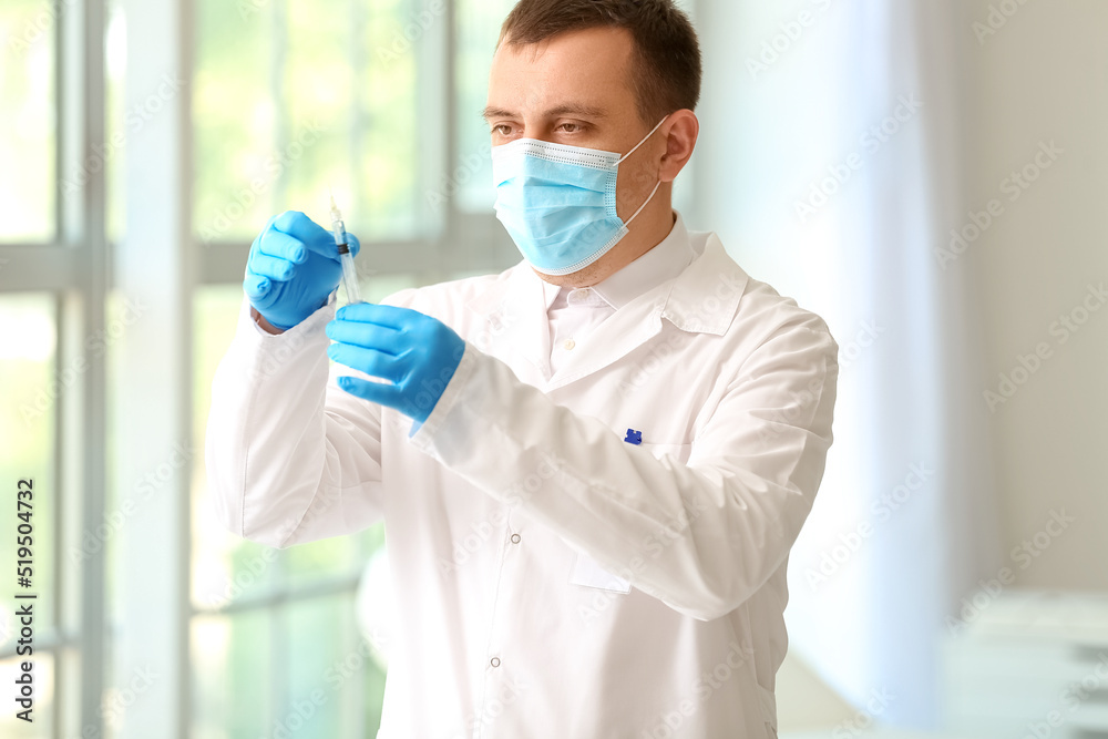 Male doctor with syringe in clinic