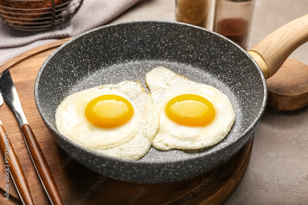 Frying pan with tasty eggs on table, closeup Frying pan with tasty eggs on table, closeup