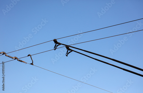 Trolley bus wires against the blue sky
