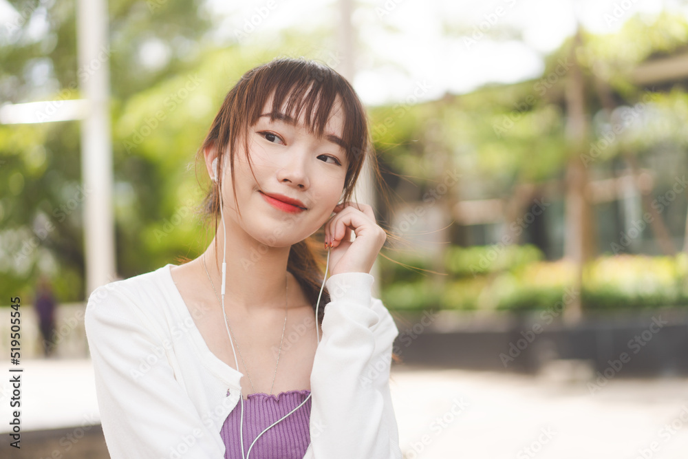Young adult asian college student woman use earphone listening for music appreciation with smile happy face Young adult asian college student woman use earphone listening for music appreciation with smile happy face