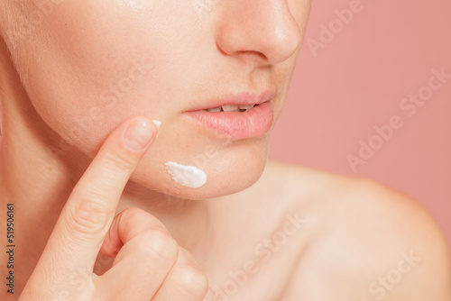 young woman applying moisturizer