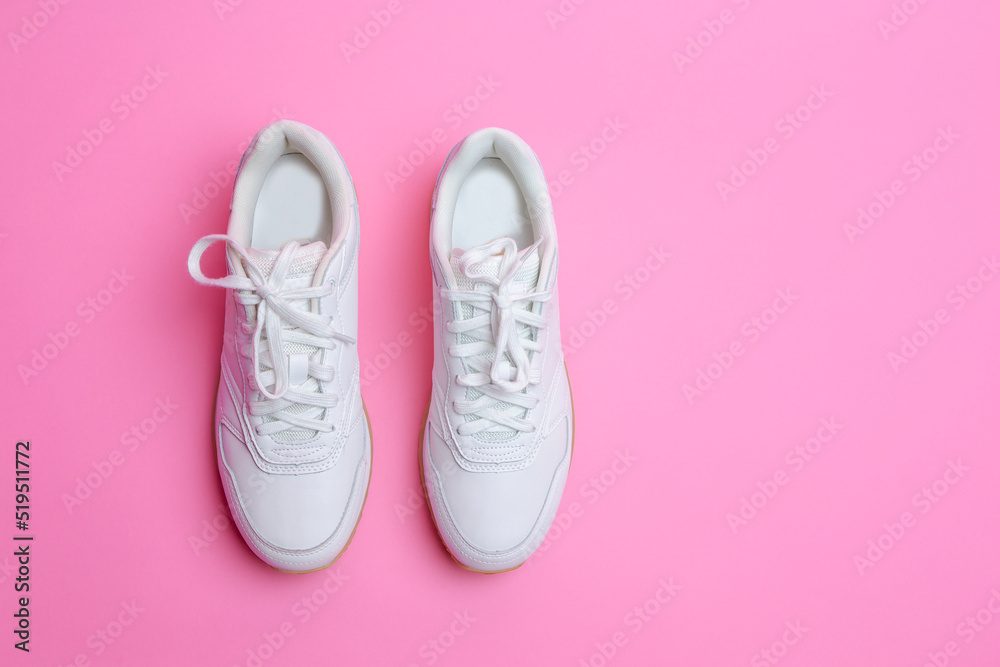 Upper View of Pair of New White Sneakers Over Pink Seamless Background. Upper View of Pair of New White Sneakers Over Pink Seamless Background.