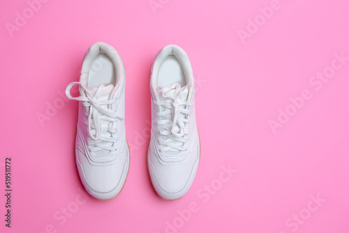Upper View of Pair of New White Sneakers Over Pink Seamless Background.