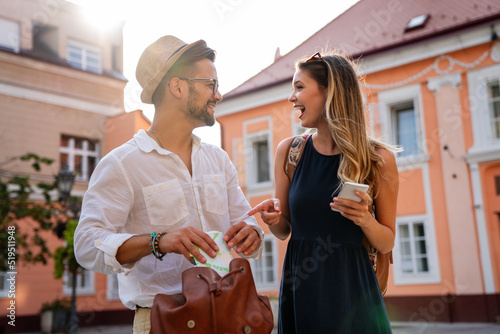 Happy young couple of travellers with map having fun on vacation together. People happiness concept