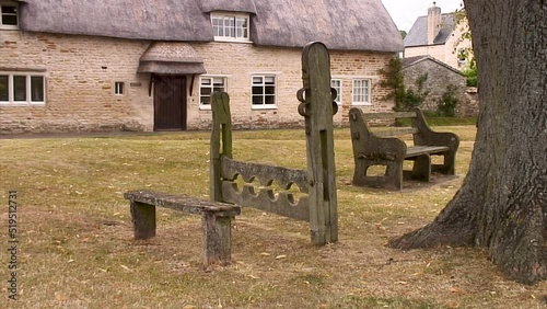 Stocks and whipping post on the village green in the Rutland village of Market Overton, England, UK