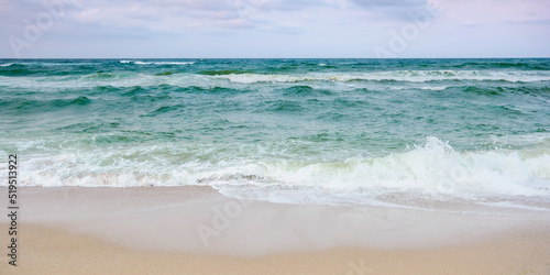 stormy weather in velvet season. seascape with clouds in evening light. waves crashing sandy beach. windy weather