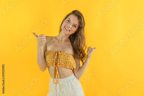 Joyful girl rejoices at the sale, smiles and shows nice with her hands. Concept of omg discounts, sale, gifts.