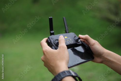 A man holds a remote controller with his hands and controls the drone. New technologies and innovations concept.