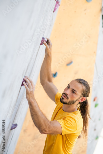 Athletic male climbing on a climbing wall.