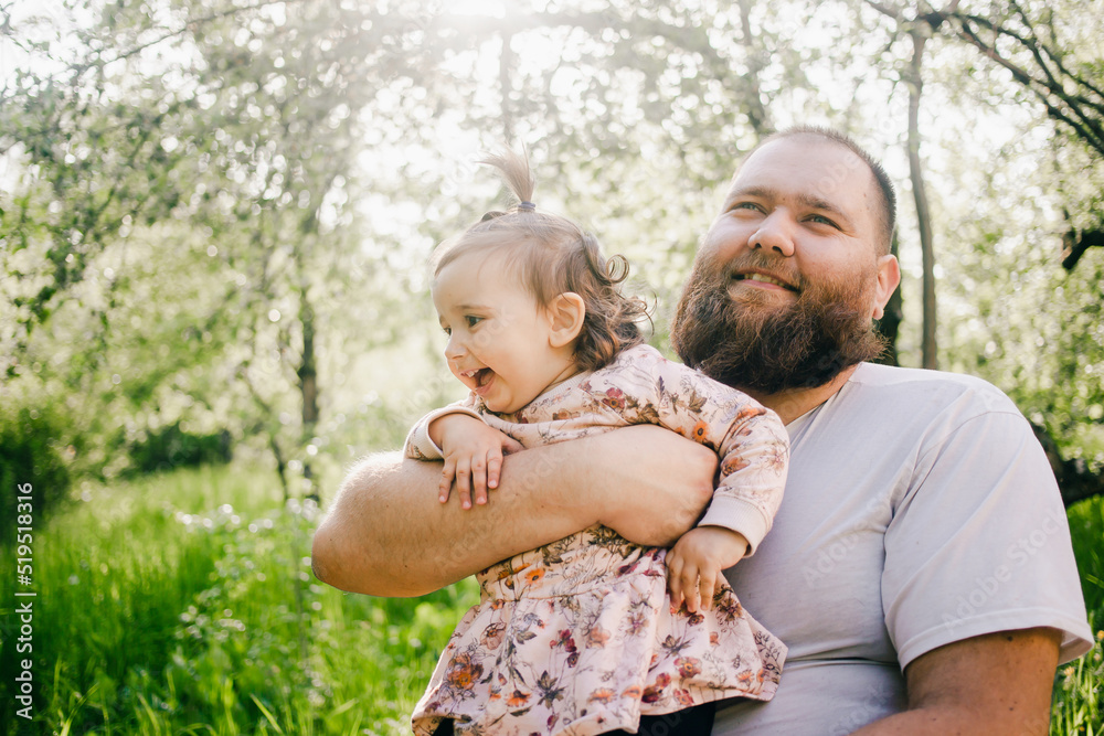 Father holding daughter on the hands and smiling. Spring time Father holding daughter on the hands and smiling. Spring time