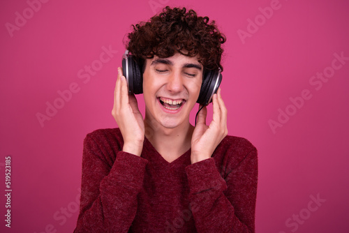 A young attractive guy listens to music on headphones.