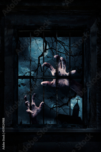 Zombie hand rising out from old damaged wood window with wall over cross  church  dead tree  full moon and spooky cloudy sky  Halloween mystery concept