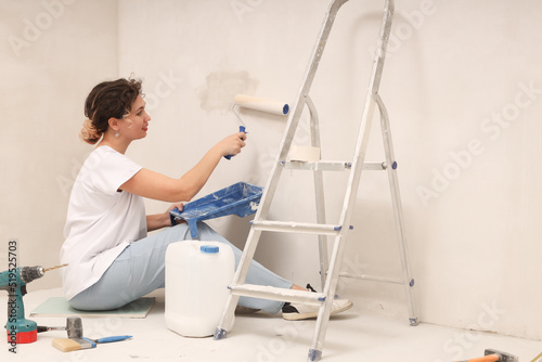 Young woman priming the wall