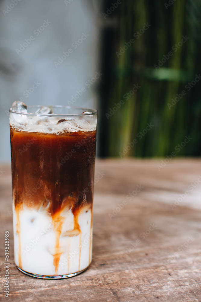 Iced caramel macchiato coffee on wooden table.
Iced caramel macchiato coffee on wooden table.