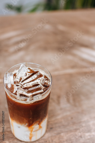 Iced caramel macchiato coffee on wooden table.

