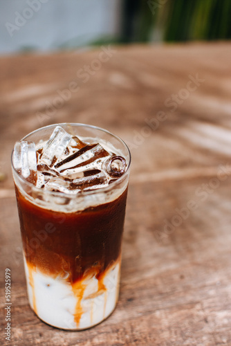 Iced caramel macchiato coffee on wooden table.
